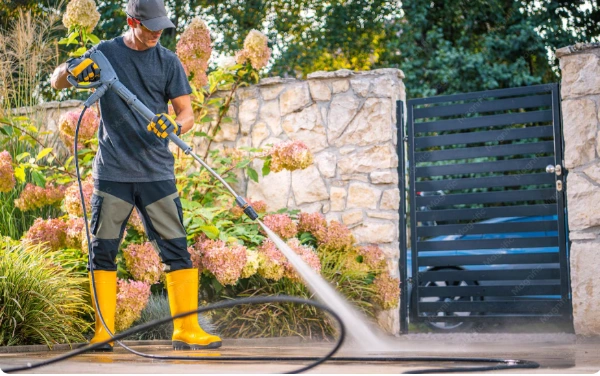 Professional technician soft washing home exterior and deck in Eugene OR